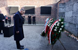 Polish President Andrzej Duda pays his tribute in front of wreaths at the so-called Death Wall next to the former Block 11 of the former Auschwitz I main camp